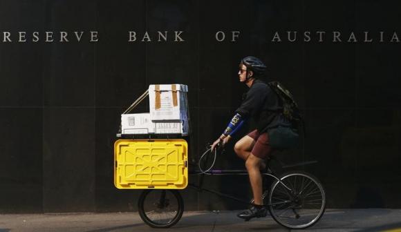 A worker on his bike rides past the RBA building in central Sydney